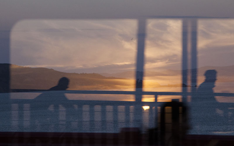 Cyclists at sunset thru window